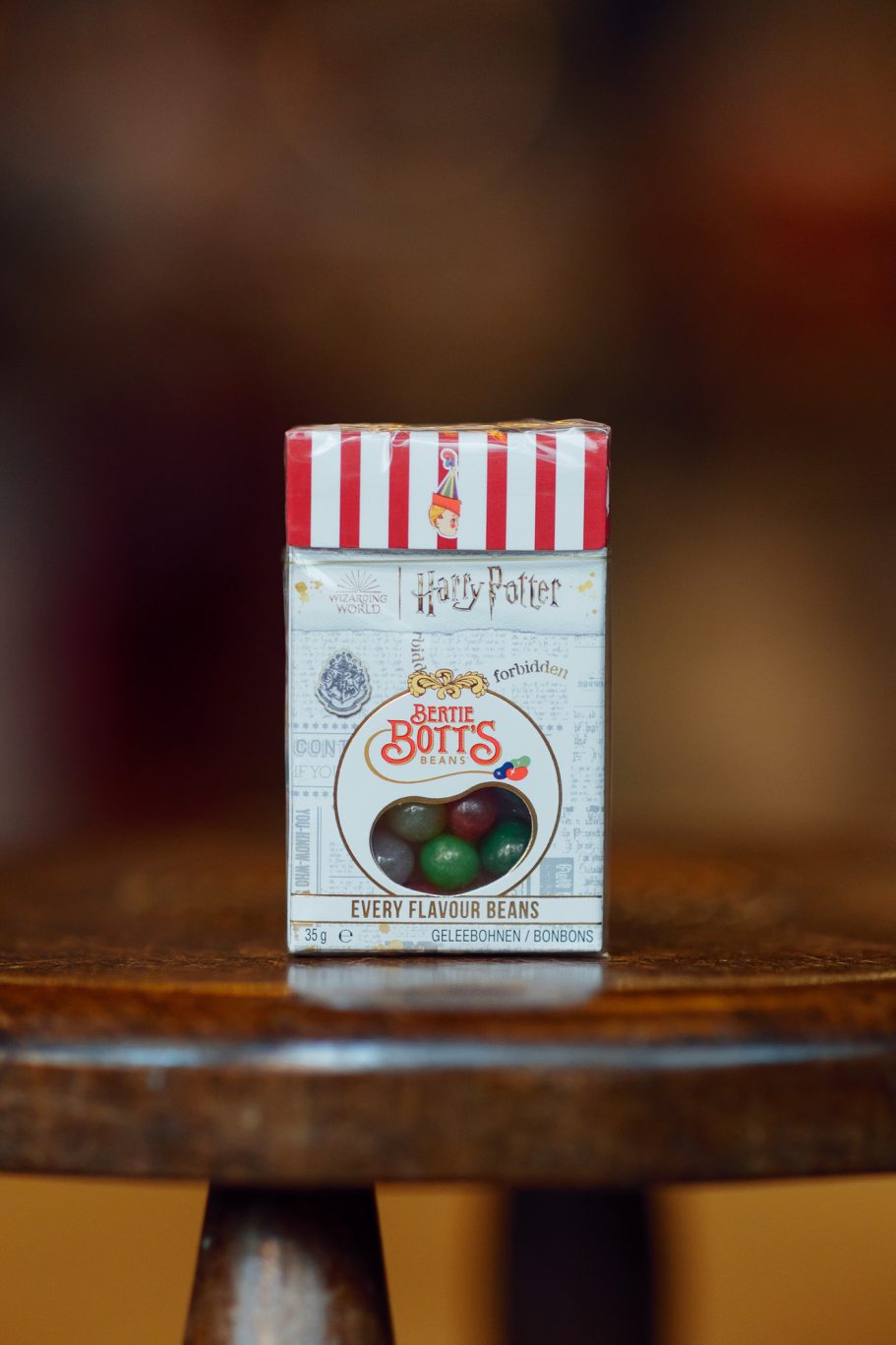Bertie Bott's Bohnen jeder Geschmacksrichtung Eine Schachtel mit Schokoladenkeksen, rot-weiß gestreift, auf einem Holzstuhl.